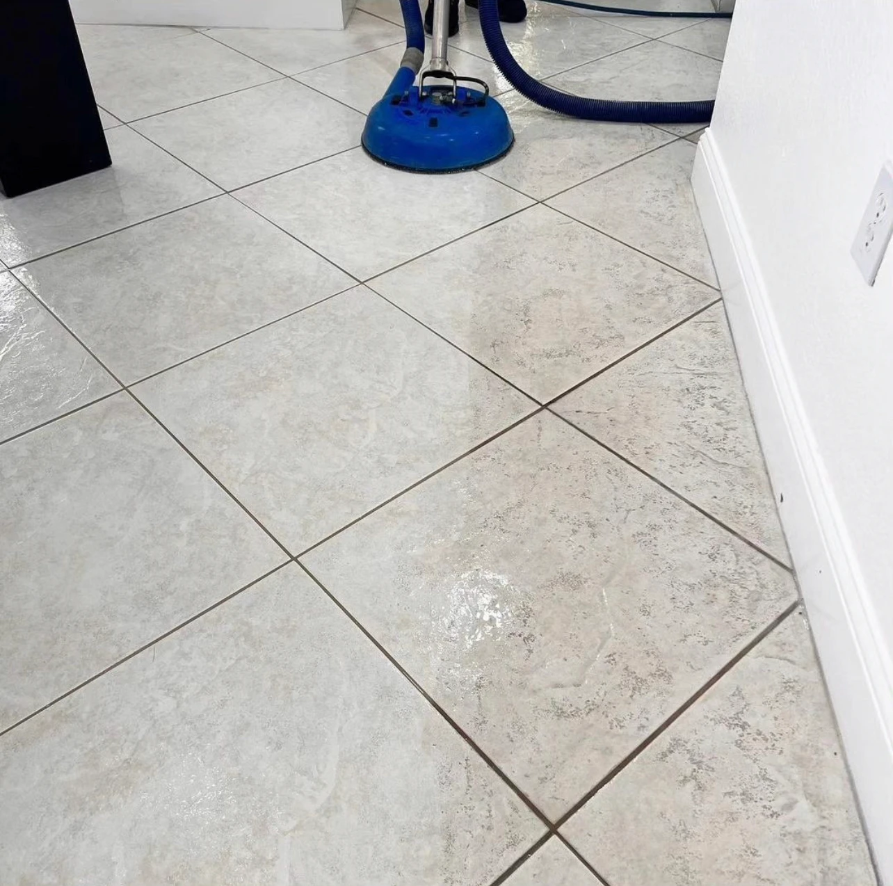 Steam spinner deep-cleaning a beige tile floor