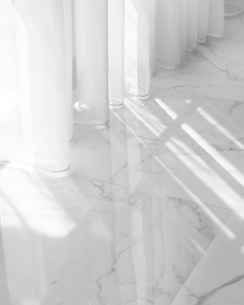 Sunlit white marble floor with a mirror finish